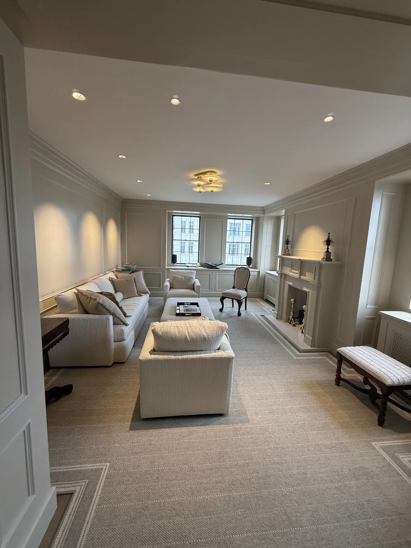 Finished living area with fireplace surround, wall moulding, and trim